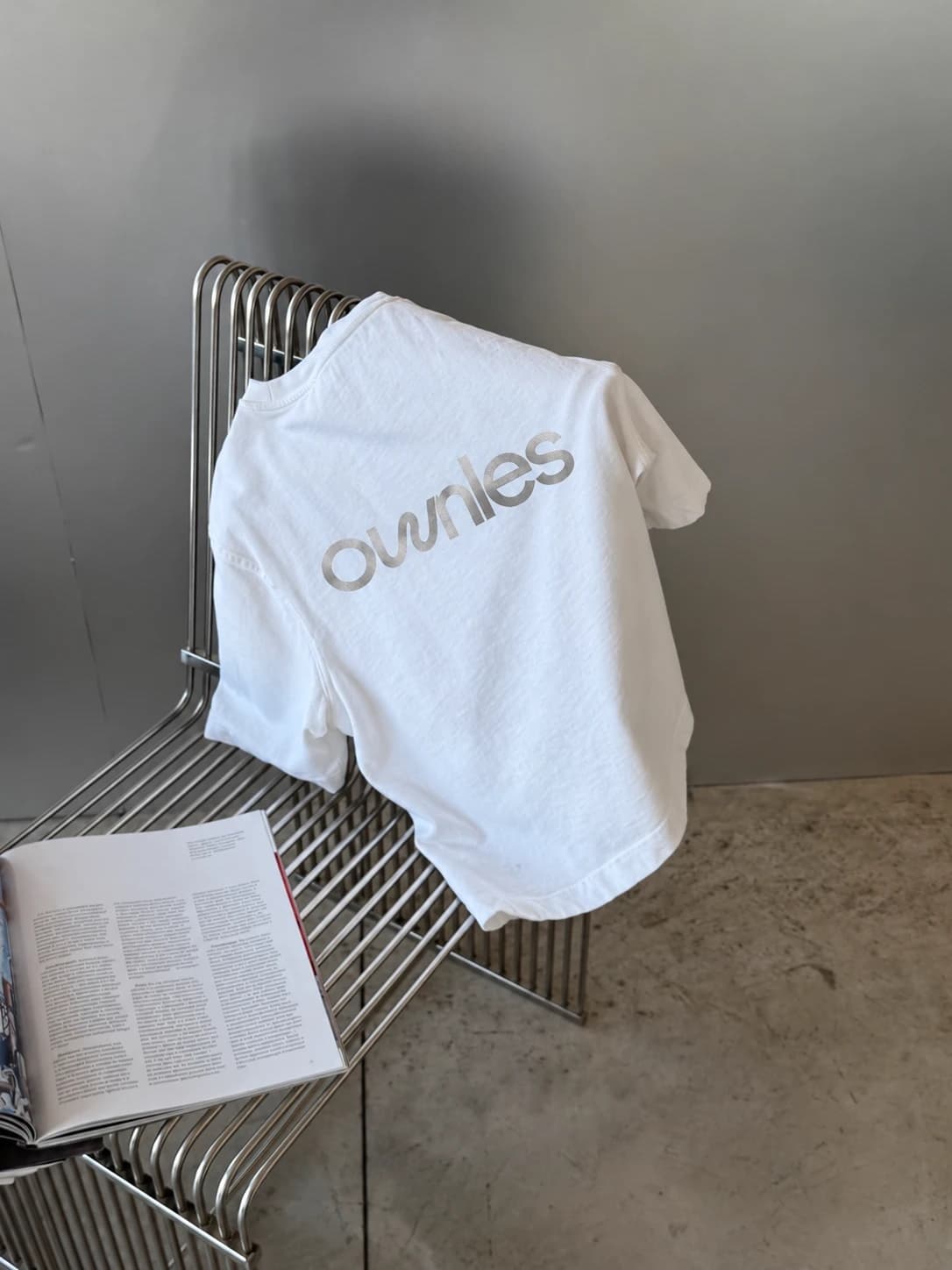 Camiseta con el logo de Ownles sobre una silla